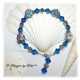 Designs by Debi Handmade Jewelry Oceans of Aloha Blue, Pink and Yellow Aloha Floral Round Beads, Silver Flowers and Swarovski Crystal Capri Blue Bicones Bracelet with a Silver Magnetic Clasp
