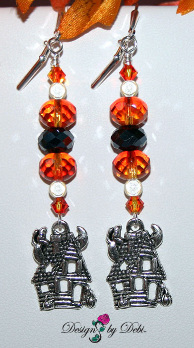 Earrings of Designs by Debi Handmade Jewelry for Charity Set October 2012 to benefit Born This Way Foundation. A one of a kind Halloween theme lariat necklace and earrings made with Swarovksi and other crystals in black, black diamond, fire opal and purple velvet, a unique Haunted House focal piece, black curb chain, a white glass ghost, haunted house, spider web and padlock charms, a white glass bone pendant bead and a large silver skeleton key. Copyright Designs by Debi.