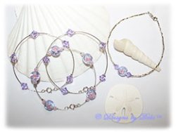 Designs by Debi Handmade Jewelry Aloha Collection Bangle Trio and Anklet Set. Features a trio of silver bangles with tanzanite and pink aloha floral beads and swarovski crystal violet bicones and a matching anklet.
