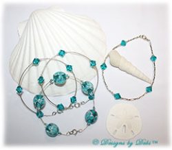 Designs by Debi Handmade Jewelry Aloha Collection Bangles and Anklet Set. Features a trio of silver bangles with aqua aloha floral beads and swarovski crystal blue zircon bicones and a matching anklet.