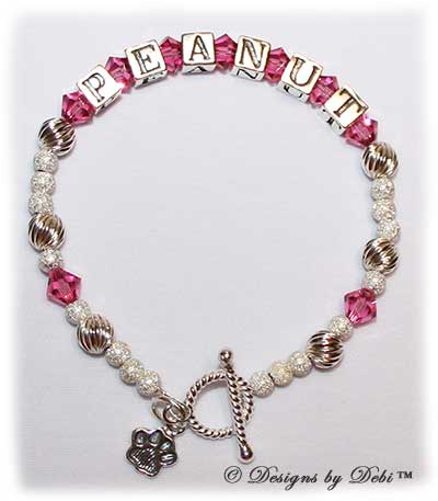 Designs by Debi Handmade Jewelry Karen Style Pet Keepsake Bracelet in the Twist and Stardust bead combination with Pink (October) crystals, a bright rope toggle clasp and Paw charm.
