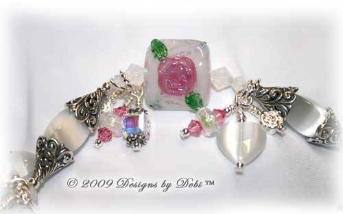 Roses on the Glistening Snow Handmade Bracelet made with artisan handmade lampwork beads, Bali silver, Swarovski crystal, and cat's eye with a toggle style clasp. Close-up.
