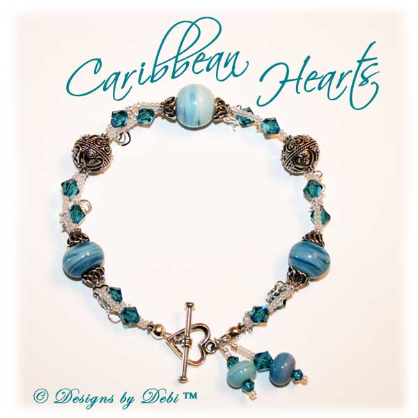Designs by Debi Handmade Jewelry January 2011 Jewelry for Charity Piece Caribbean Hearts. Teal, white and sterling silver one of a kind lampwork bracelet to raise money for the National Cervical Cancer Coalition. The bracelet has a heart theme...handmade lamwork beads swit=rled in white and caribbean blues, swarovski teal indicolite bisone crystals, tiny pearly white seed beads, round Bali beads with a repeating heart design, sterling silver heart link chain and a sterling silver heart toggle. OOAK