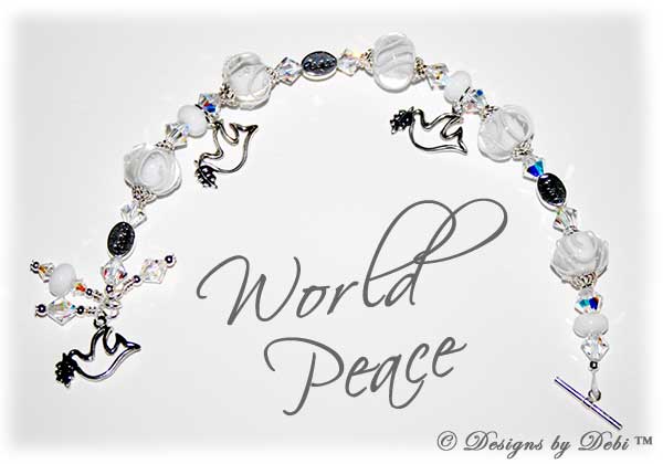 Designs by Debi Handmade Jewelry World Peace one of a kind ooak handmade white and clear lampwork and ab crystal bracelet made in honor of world peace day to raise money for Teaching Tolerance. It was made with clear lampwork beads scrolled with white, swarovski ab crystal bicones, sterling silver dove charms, sterling silver peace message beads and a sterling silver dove toggle clasp.