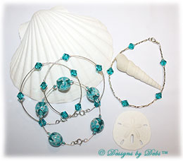 Designs by Debi Handmade Jewelry Aloha Collection Bangles and Anklet Set. Features a trio of silver bangles with aqua aloha floral beads and swarovski crystal blue zircon bicones and a matching anklet.