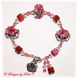Designs by Debi Handmade Jewelry Aloha Collection Raspberry Hibiscus Bangle Bracelet. Features gorgeous raspberry pink hibiscus handmade lampwork beads, dark pink cat's eye cubes, silver filigree bead caps, swarovski crystal rose and crystal ab bicones, a silver hibiscus charm, dangles and a magnetic clasp