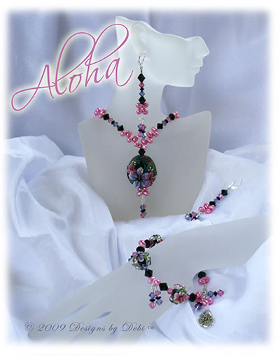 Designs by Debi OOAK one of a kind set of handmade jewelry named Aloha with pink and purple hibiscus, Swarovski crystals in black, jet, pink and tanzanite, pink freshwater pearls, necklace, earrings and bracelet