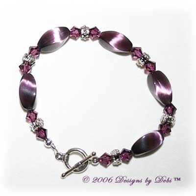 Designs by Debi Handmade Jewelry Purple Cat's Eye Twist Beads, Swarovski Crystal Amethyst Bicones and Silver Floral Rondelles Bracelet with a Silver Round Toggle Clasp