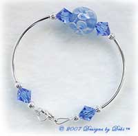 Designs by Debi Handmade Jewelry Blue Aloha Floral and Swarovski Crystal Sapphire Bicones Curved Tube Bracelet with a Silver Lobster Clasp