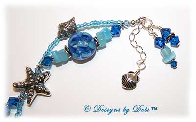 Designs by Debi Jewelry for Charity Piece for August 2010 to raise money for The Donald Paterson Recovery Fund. A one-of-a-kind artisan handmade bracelet with blue ribbon waves round handmade glass beads, thai silver starfish beads, swarovski crystal aquamarine and capri blue bicones, bali sterling silver spacer beads, sterling silver conch shells, tierracast silver scallop shells, light blue cat's eye chips, seed beads and a bali sterling silver hook and eye clasp with extender chain. OOAK one of a kind