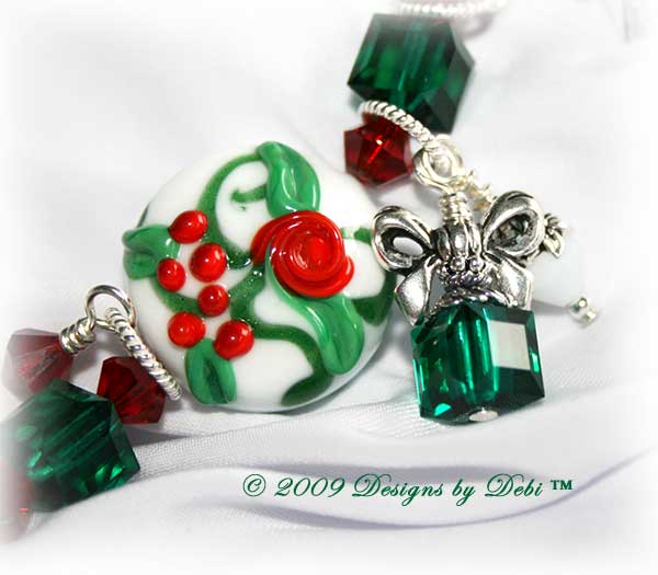 The Perfect Christmas Present Handmade Bracelet made with artisan handmade lampwork beads, Bali silver, Swarovski crystal, and cat's eye with a Bali toggle style clasp. Close-up.