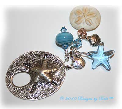 Designs by Debi Jewelry for Charity Piece for July 2010 to raise money for The Deepwater Horizon Memorial Fund. A one-of-a-kind artisan handmade bracelet with blue and beige lentil-shaped ocean within handmade glass beads, handmade glass sand dollar beads, swarovski crystal aquamarine and light peach bicones, sterling silver round beads, sterling silver sand dollar charms, sterling silver shell charms, sterling silver starfish charms, a swarovski crystal aquamarine starfish and a shiana thai sterling silver sand dollar toggle clasp. OOAK