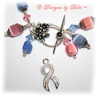 Designs by Debi Handmade Jewelry Sweet Angels one of a kind ooak handmade light pink and light blue lampwork and crystal bracelet made in honor of national pregnancy and infant loss awareness month to raise money for Missing GRACE Foundation. It was made with pink flowers on blue handmade square lampwork beads, pink and blue cat's eye beads, pink and blue crystals and sterling silver with a flower toggle clasp.