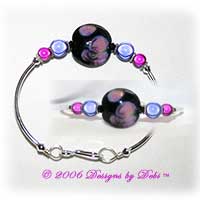 Designs by Debi Handmade Jewelry Night Water Lillies Black, Purple and Pink Artisan Handmade Lampwork Focal Bead, Swarovski Crystal Bicones and Miracle Bead Silver Fitted Bangle Bracelet with Hook Clasp