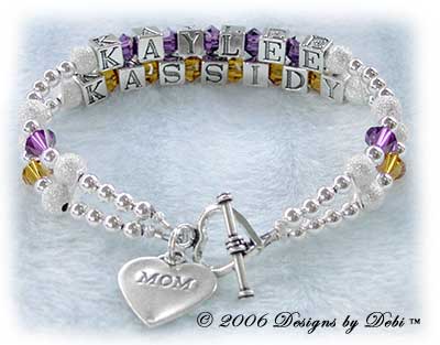 Designs by Debi Handmade Jewelry 2 strand Keepsake Bracelet in the Karen Style Stardust and Seamless Round bead combination with Amethyst (February) and Topaz (November) crystals, a heart toggle clasp and Mom heart charm. Mother's Bracelet