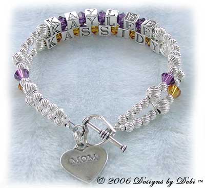 Designs by Debi Handmade Jewelry 2 strand Keepsake Bracelet in the Karen Style Twist bead combination with Amethyst (February) and Topaz (November) crystals, a heart toggle clasp and Mom heart charm. Mother's Bracelet