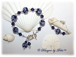 Designs by Debi Handmade Jewelry Aloha Collection Purple Bracelet and Anklet Set. Features royal purple aoha floral handmade lampwork beads, swarovski crystal purple velvet and crystal ab bicones, dangles, a silver flower toggle clasp and matching anklet.
