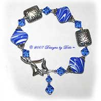 Designs by Debi Handmade Jewelry Swirled Sapphire Blue Diamond Artisan Handmade Lampwork, Swarovski Crystal Sapphire Bicones and Sterling Silver Pillows Bracelet with a Diamond Toggle Clasp ~ OOAK