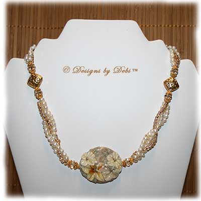 Designs by Debi Handmade Jewelry for Charity Necklace Sending Healing Aloha. A one of a kind ooak hibiscus lampwork necklace with freshwater pearls, gold beads, Bali floral pillow beads and a gold hibiscus toggle clasp.