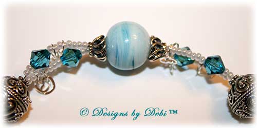 Designs by Debi Handmade Jewelry January 2011 Jewelry for Charity Piece Caribbean Hearts. Teal, white and sterling silver one of a kind lampwork bracelet to raise money for the National Cervical Cancer Coalition. The bracelet has a heart theme...handmade lamwork beads swit=rled in white and caribbean blues, swarovski teal indicolite bisone crystals, tiny pearly white seed beads, round Bali beads with a repeating heart design, sterling silver heart link chain and a sterling silver heart toggle. OOAK