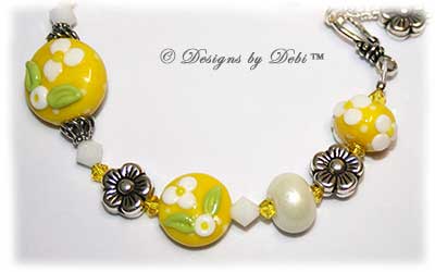 Designs by Debi Handmade Jewelry for Charity Bracelet and Earrings Set Hope for a Bright Future. The one of a kind ooak bracelet features handmade artisan lampwork glass beads, sterling silver flower beads, Swarovski citrine and white alabaster bicones, a sterling silver hook clasp and extender chain with charms. The one of a kind earrings are leverback style with matching beads, crystals and chain.