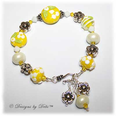 Designs by Debi Handmade Jewelry for Charity Bracelet and Earrings Set Hope for a Bright Future. The one of a kind ooak bracelet features handmade artisan lampwork glass beads, sterling silver flower beads, Swarovski citrine and white alabaster bicones, a sterling silver hook clasp and extender chain with charms. The one of a kind earrings are leverback style with matching beads, crystals and chain.