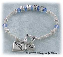 Designs by Debi Handmade Jewelry Personalized Pet Name Keepsake Bracelet in the Karen Style Twist and Stardust bead combination with Sapphire (September) crystals, a heart toggle, Mom heart charm and additional Paw heart charm.Mother's Bracelet Doggie Mom Bracelet