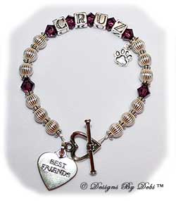 Designs by Debi Handmade Jewelry Pet Name Keepsake Bracelet in the Ali Style Corrugated with Antiqued Daisies bead combination, Amethyst (February) crystals, a heart toggle, Best Friends heart charm and additional Paw charm added at the end of the name. Dog Best Friend Bracelet